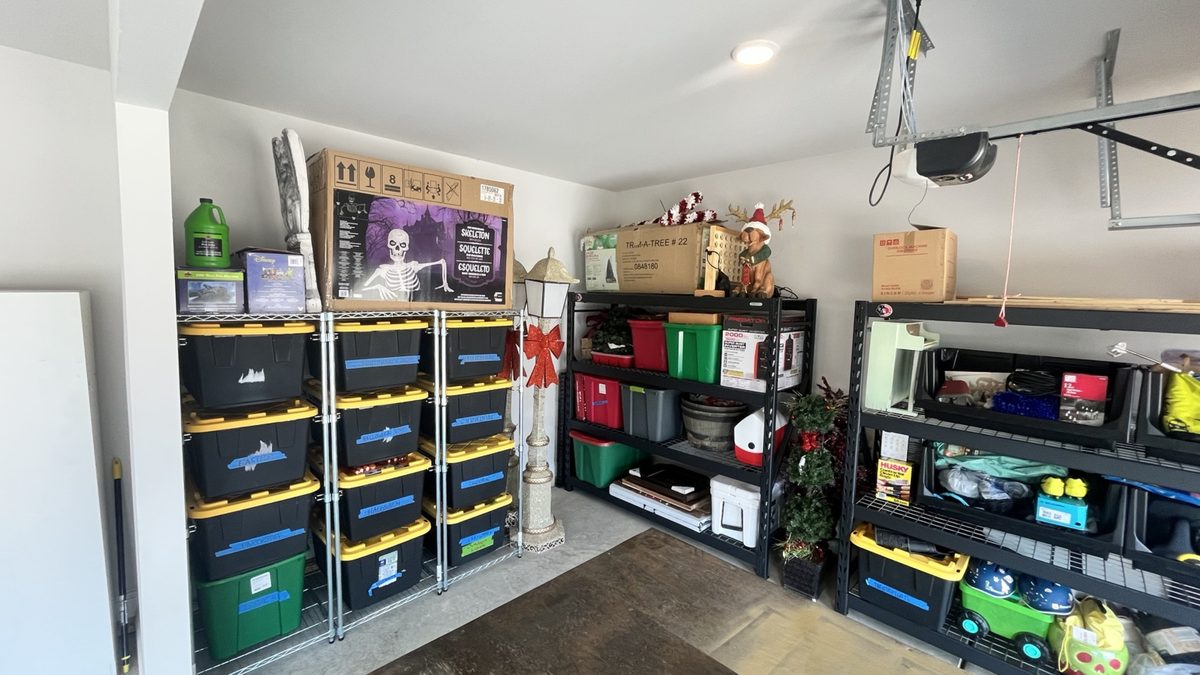 After: labeled bins and seasonal boxes arranged on metal shelving units along the walls, with the floor clear