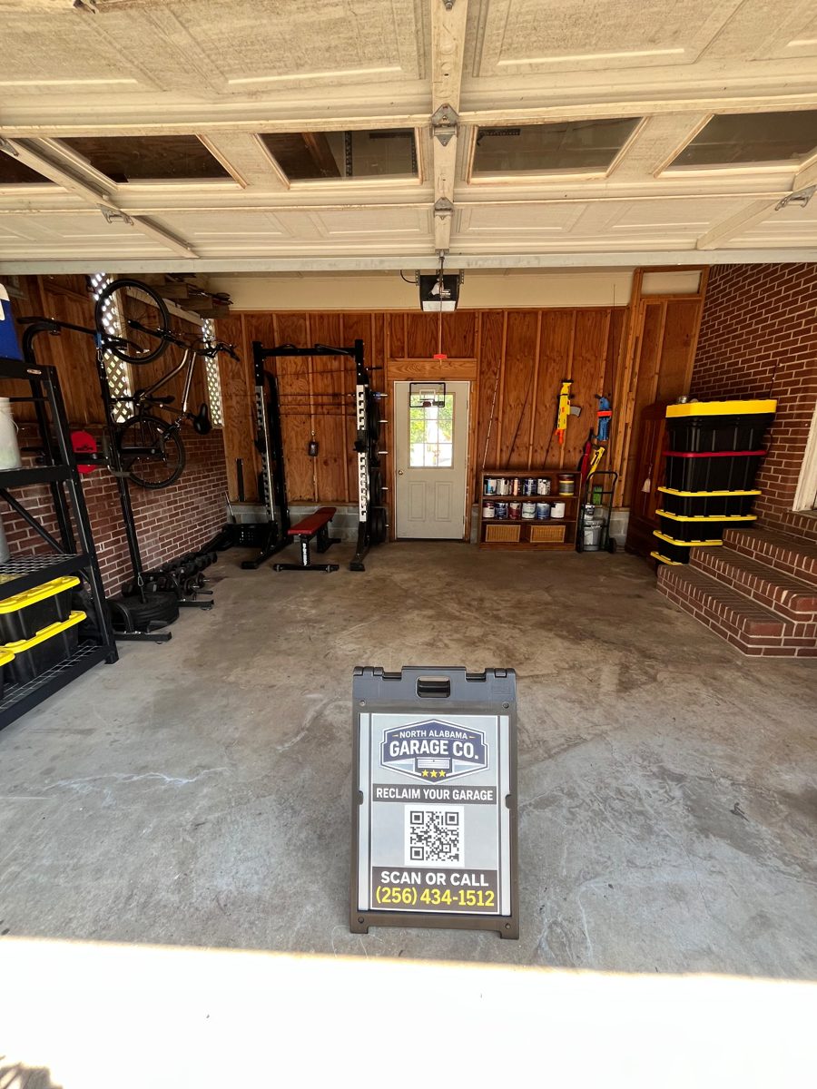 After: the same garage with a clear floor, a bike hung on the wall, shelving with bins, and the workout rack and bench set against the back wall