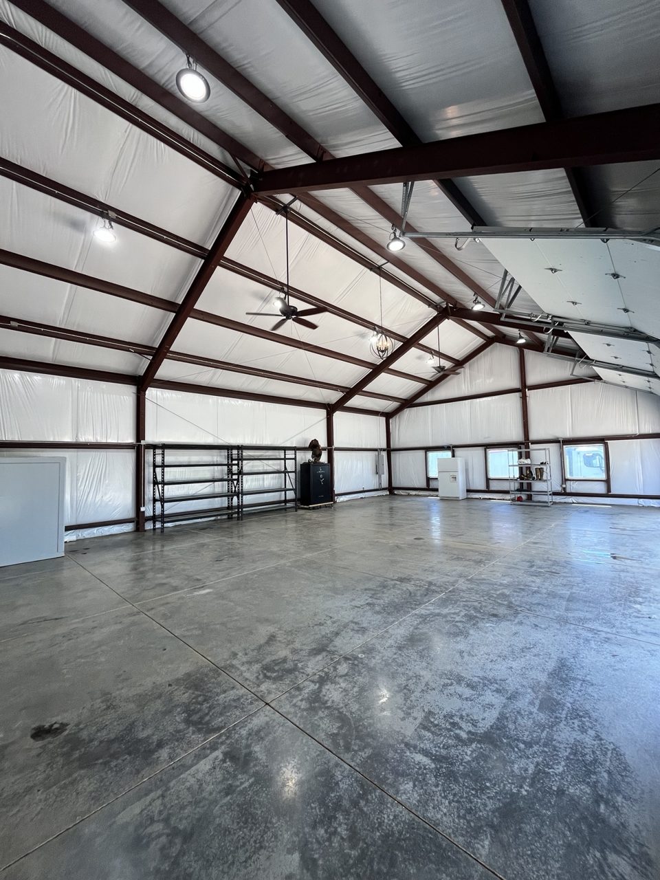 After: the same shop with a clean, open floor, cleaned walls and ceiling, and a few shelving units and items along the walls